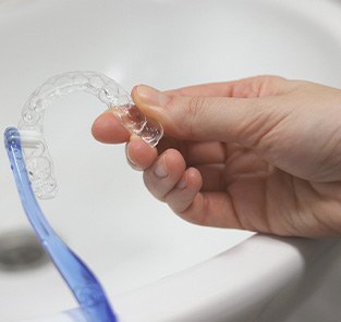 Patient cleaning clear aligner with toothbrush