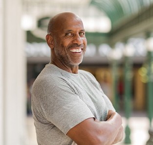 Man in gray shirt smiling outside