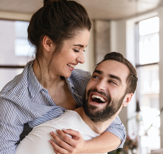 Man and woman smiling after clear aligner treatment