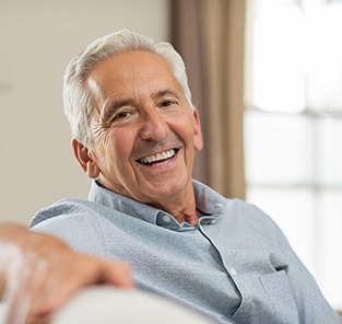 Senior man sitting on a couch and smiling
