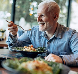 Senior man smiling and enjoying a meal