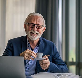 Senior man drinking coffee at work desk