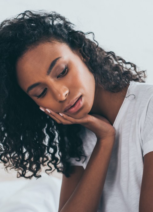 Woman in need of emergency dentistry holding jaw