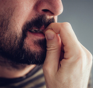 closeup of man biting his fingernails
