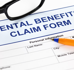 Top of Dental Benefits Claim Form with blue pen and black framed glasses