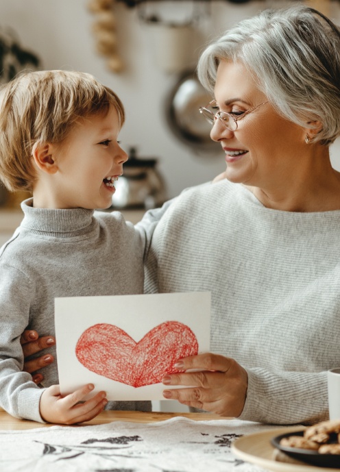 Grandmother smiling at grandchild after dental implant tooth replacement