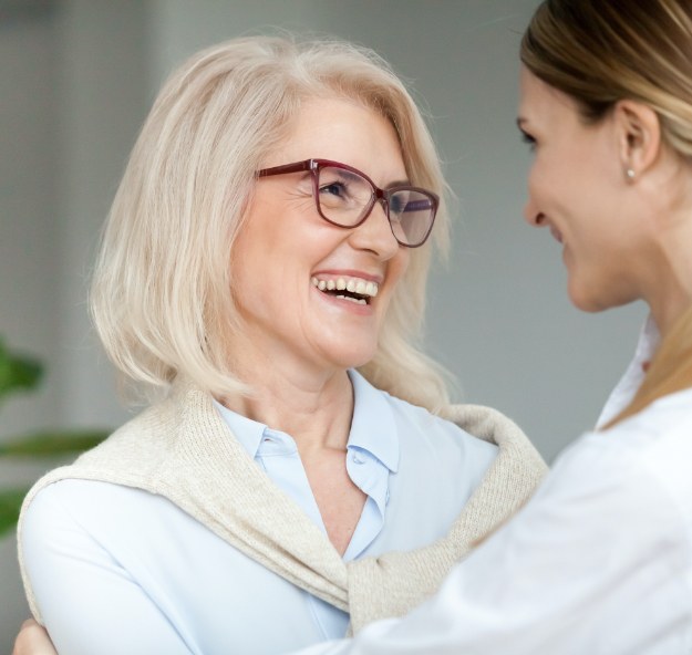 Older woman sharing flawless smile after dental implant tooth replacement