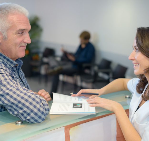 Dental patient and team member discussing the cost dental implants