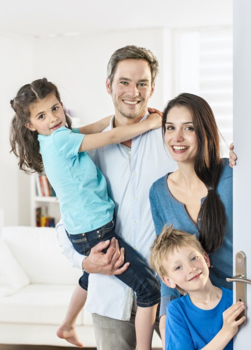 Family of four smiling after visiting the dentist