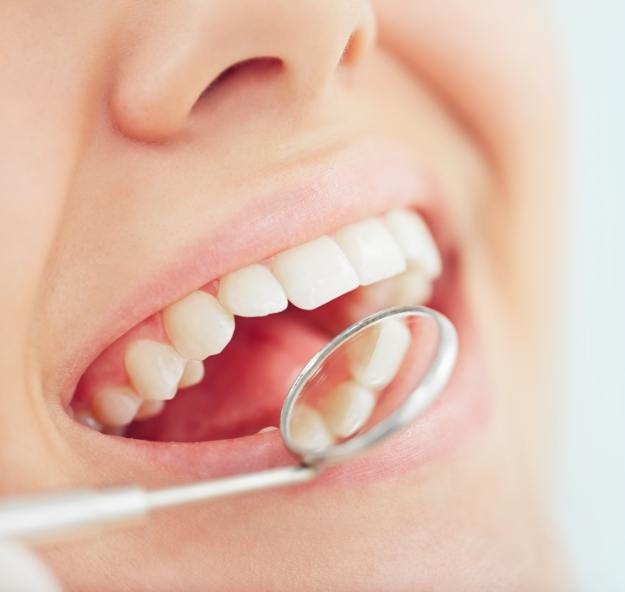 Dentist examining patient's smile after tooth colored filling restoration