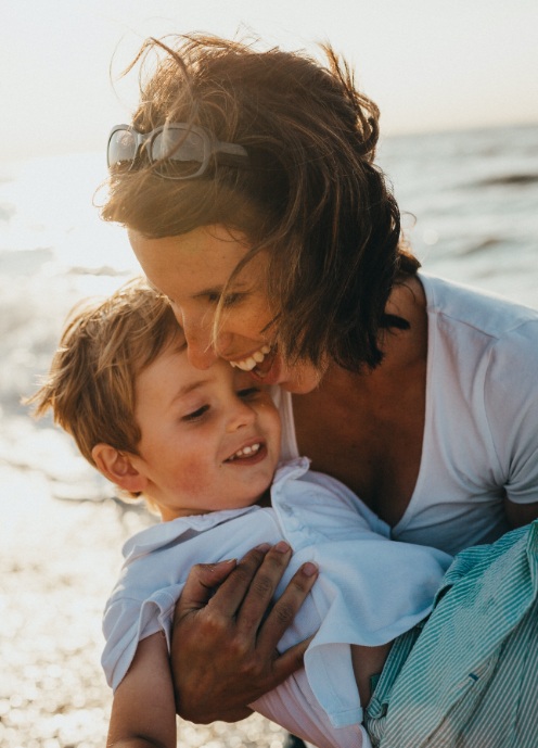 Mother and child smiling together after receiving dental services