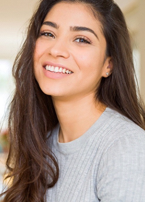 Woman with beautiful teeth smiling in apartment