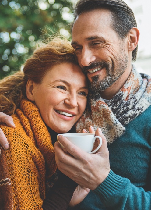 Man and woman smiling together after visiting the dentist