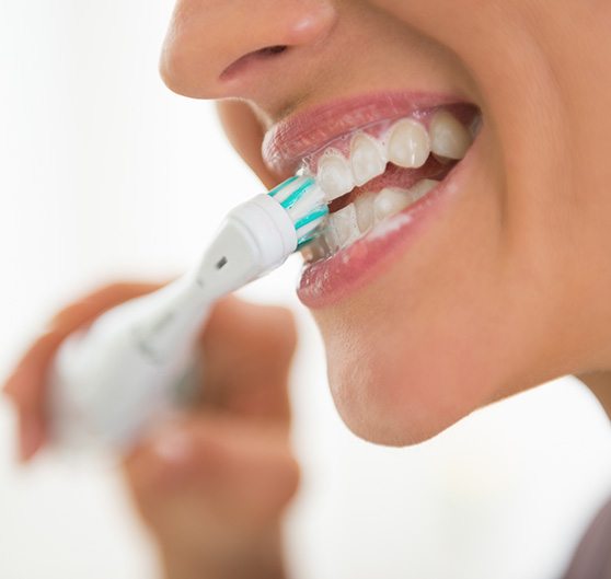 Nose-to-chin profile view of woman brushing her teeth