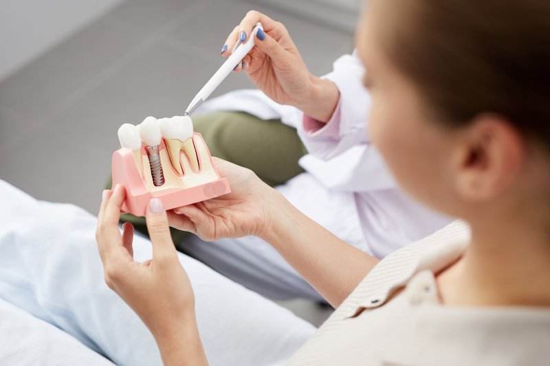 person looking at dental implant