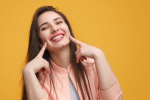 Smiling woman pointing to her teeth