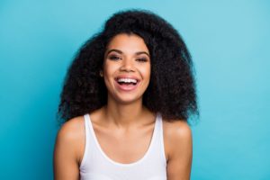 Woman in white tank top smiling.