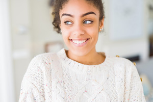 Young woman in white sweater smiling