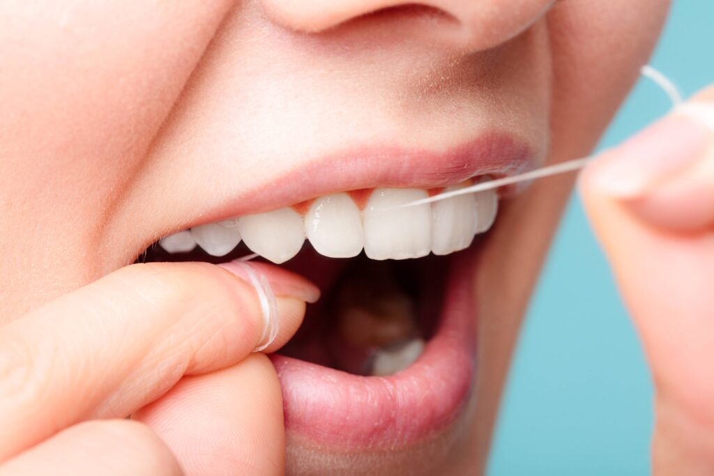 Closeup of patient flossing their teeth