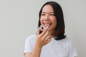 Woman putting on her clear aligners